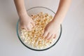 Children`s hands take popcorn in a plate. background for popcorn and movie day decoration.