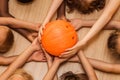 Children`s hands of different nationalities with a bowling ball