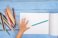 Children`s hands draw with pencils in the album on the blue table Royalty Free Stock Photo