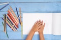 Children`s hands draw with pencils in the album on the blue table Royalty Free Stock Photo