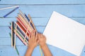 Children`s hands draw with pencils in the album on the blue table Royalty Free Stock Photo