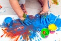 Children`s hands and feet in blue paint. finger paints. Baby artwork