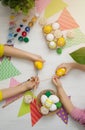 Children& x27;s hands hold Easter eggs on the background of a white wooden table. Children paint eggs. Happy Royalty Free Stock Photo