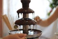 Children`s hands hold fruit on a stick in a chocolate fountain Royalty Free Stock Photo