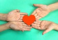 children's hands hold a heart cut out of red paper. Children give love and warmth concept. Peace love in