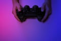 Children& x27;s hands hold a joystick, gamepad, playing video games in ultraviolet light Royalty Free Stock Photo