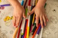 Children& x27;s hands hold pencils and felt-tip pens on the background of a large Easter coloring page Royalty Free Stock Photo