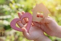 Children`s hands hold a wooden house and a heart, top view. The idea is peace and quiet in a house where love reigns. Soft focus,