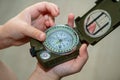 Children`s hands holding a compass. A little boy holds a green compass in his hands. Learn orienteering. Childhood curiosity and