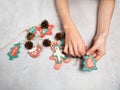 Homemade home decoration for Christmas. Children`s hands are holding a homemade garland. Gingerbread men are made of salted dough