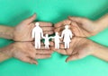 children's hands holding a silhouette of a family cut out of paper on a green background. children's dreams, Royalty Free Stock Photo