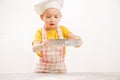 Children`s hands kneading dough. Cheerful cook child boy in cap prepares burritos Royalty Free Stock Photo