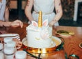 Children`s hands little girls reach for the cake. Big beautiful cake unicorn on the birthday of little Princess on festive table