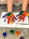 Children`s hands in multi-colored paint