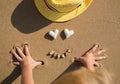 Children`s hands play with pebbles on the sand on the coast Royalty Free Stock Photo