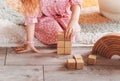 Children`s hands play in wooden cubes. Designer for children made of wood