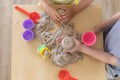 Children`s hands playing with kinetic sand and toys on the table. Royalty Free Stock Photo