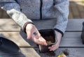 Children`s hands put plant seeds in a seedling pot, standing on a wooden table.