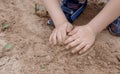 Children`s hands in the sand. The child rakes the wet sand with his hands. Dirty hands. Royalty Free Stock Photo