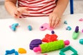 Children`s hands sculpt pink heart from plasticine on white table, children`s educational games, home creativity, play dough, gi Royalty Free Stock Photo