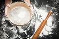 Children`s hands sift the flour on the kitchen table