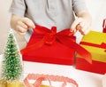 Children& x27;s hands tie a red bow on a gift box. Christmas family traditions. Cozy holiday interior Royalty Free Stock Photo