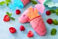 Children`s ice cream popsicles strawberry-raspberry sorbet on blue concrete background Royalty Free Stock Photo