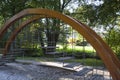 Interactive playground. A wooden arch with a short flight of stairs for balancing on chains. A game for kids.