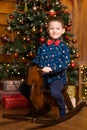 Children`s joyful memories of Christmas holidays. Santa gave a little boy a swing horse Royalty Free Stock Photo