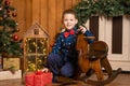 Children`s joyful memories of Christmas holidays. Santa gave a little boy a swing horse Royalty Free Stock Photo