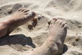 Children`s feet covered with sea sand