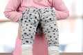 Children`s legs hanging down from a chamber-pot on a pink background Royalty Free Stock Photo