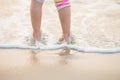 Children`s legs stand on the beach. Royalty Free Stock Photo