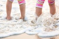 Children`s legs stand on the beach. Royalty Free Stock Photo