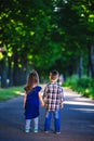 Children`s love, a little boy and a girl, having fun, laugh and smile, and kiss outdoors. back view Royalty Free Stock Photo