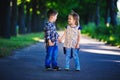 Children`s love, a little boy and a girl, having fun, laugh and smile, and kiss outdoors Royalty Free Stock Photo