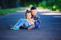 Children`s love, a little boy and a girl, having fun, laugh and smile, kiss and sits outdoors Royalty Free Stock Photo