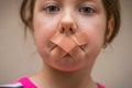 Children`s mouth sealed with a plaster close-up. The little girl`s mouth was covered with duct tape. A sad, scared child can`t Royalty Free Stock Photo