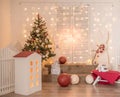 Children`s New Year`s decor in the studio. On a white brick wall, lights, hares, tree Royalty Free Stock Photo