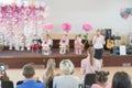 Children's party in primary school. Young children on stage in kindergarten appear in front parents. blurry