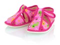 Children`s pink slippers on the white background with shadow reflection.