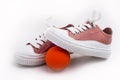 Children`s pink sneakers with white laces and a ball Royalty Free Stock Photo