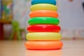 Children`s plastic pyramid, composed of colored rings on yellow background Royalty Free Stock Photo