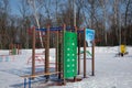 children's playground with a basketball hoop, stairs and obstacles on the edge of the forest in winter