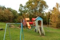 Children`s playground of houses and slides with swings on the background of trees in the city park Royalty Free Stock Photo