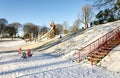 Children`s playground and kids riding from a snowy slope in Duthie park, Aberdeen, Scotland
