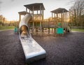 Children's playground wooden fun play structure fort with ramp, slide, bridge and climbing wall. Royalty Free Stock Photo