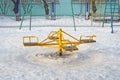 Children`s revolving carousels in the ordinary courtyard of an apartment building. Russia. Winter