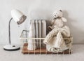 Children`s room interior. A table lamp, a basket with books and toys on the table. Scandinavian style simple interior