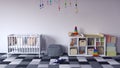 Children`s room with white cradle for baby and shelf with toys